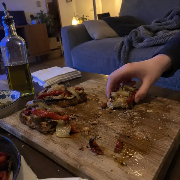 Tostadas de escalivada con pimiento rojo, berenjena y cebolla asados en una tabla sobre la mesa del salón